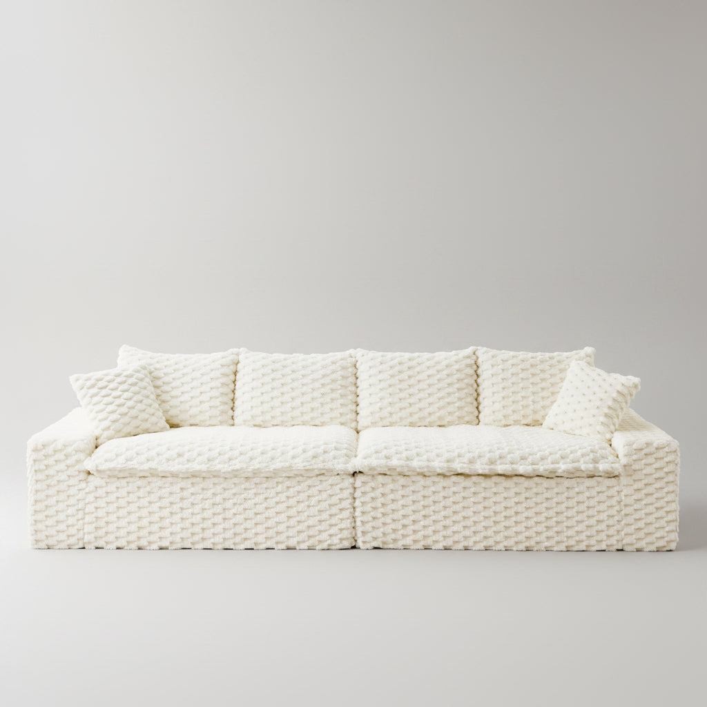 White textured sofa in a living room setting with decor elements.